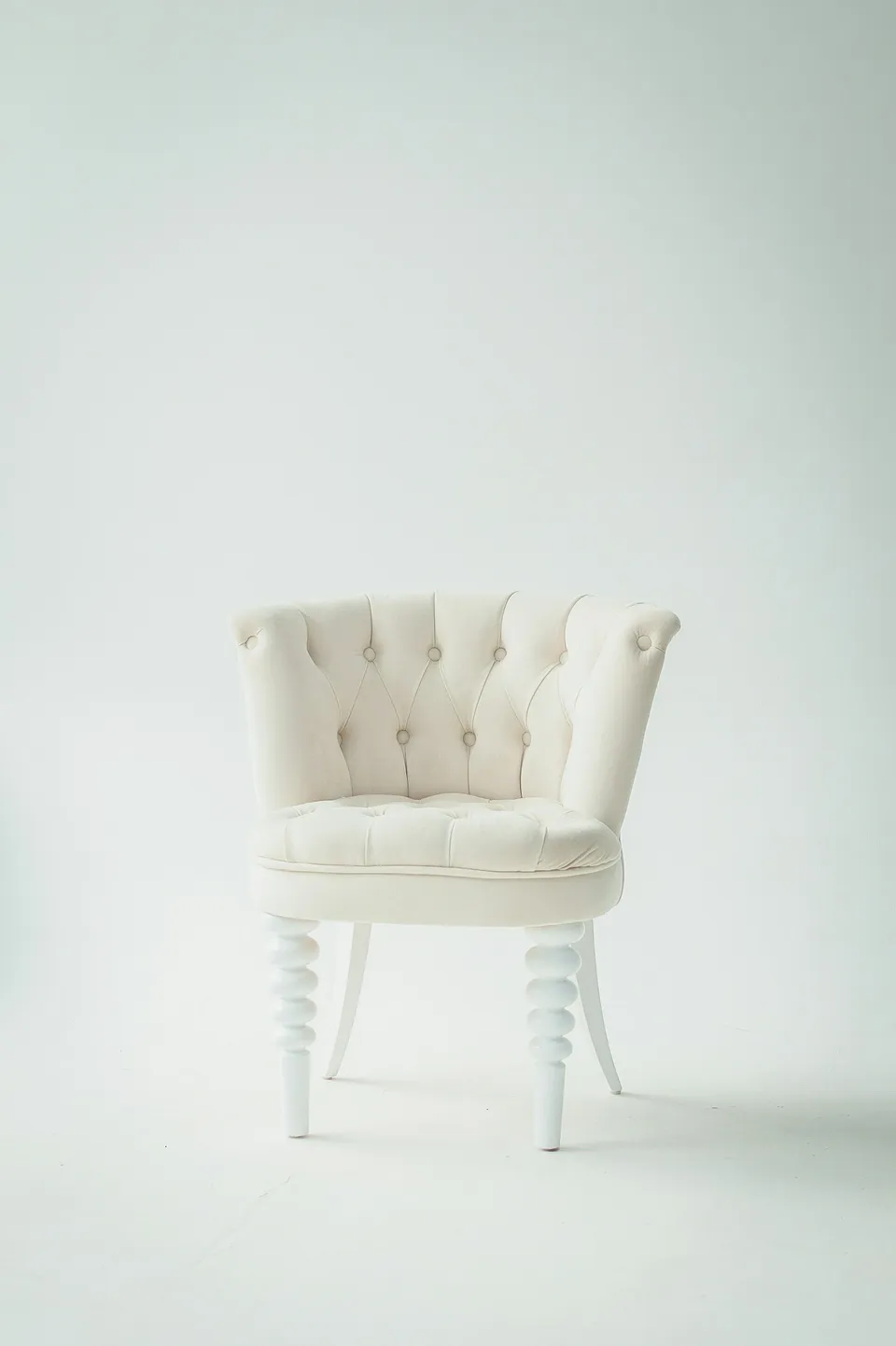 Silla clara con respaldo capitoné y patas de madera.
